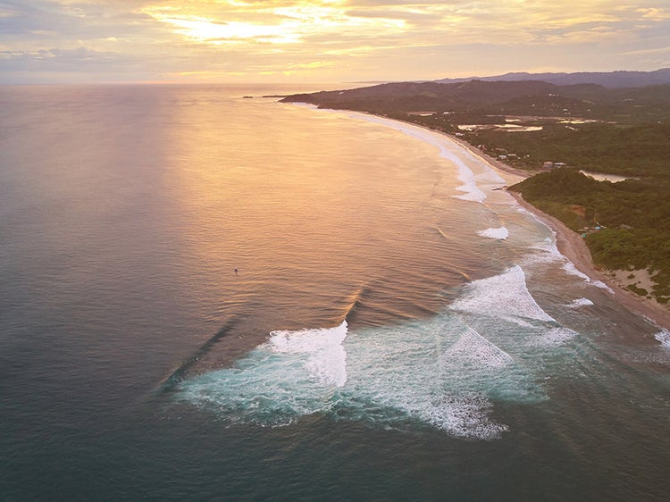 Aerial drone view of a famous surfing bay at sunset