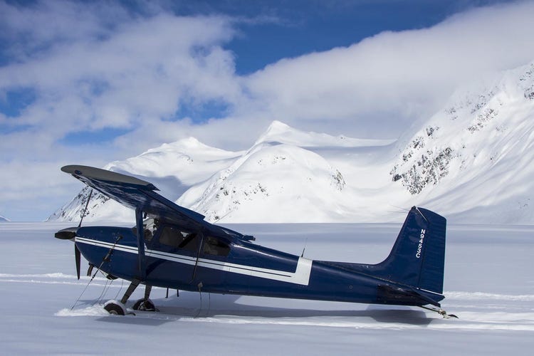 Small float plane on a gravel airstrip in the Alaskan wilderness